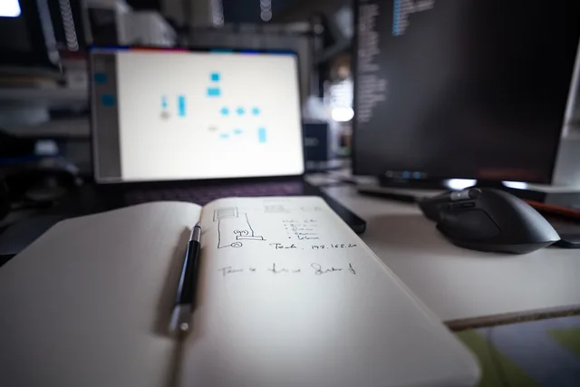 Close-up of a modern desk setup featuring notebooks, monitors, and a computer mouse. Copying a live workflow into a test environment